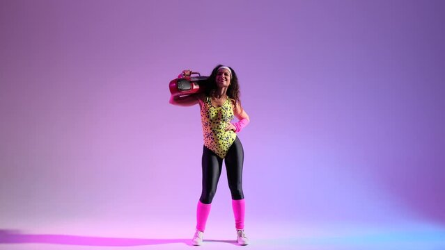 Nerdy woman in a retro ensemble, dances on a vibrant purple backdrop. Holding in hands, a classic boombox, amplifying the atmosphere with a burst of retro energy.