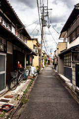 Typical and authentic street in Kyoto, Japan in vertical shot with bicycle in foreground and Japanese traditional architecture