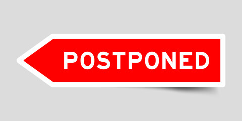 Red color arrow shape sticker label with word postponed on gray background