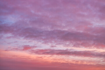 A beautiful sky tinted by the sun leaving vibrant shades of gold, pink, blue and multicolored. Clouds in the twilight evening and morning sky. Cloudy sky background in the evening and during the day.