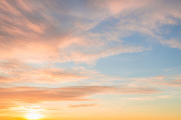 A beautiful sky tinted by the sun leaving vibrant shades of gold, pink, blue and multicolored. Clouds in the twilight evening and morning sky. Cloudy sky background in the evening and during the day.