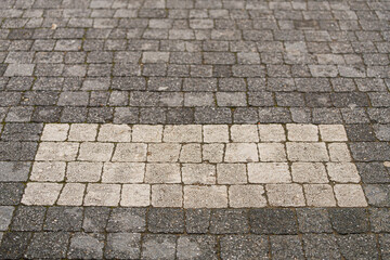 Fototapeta premium The floor is paved with gray stones, top view. stone texture, outdoor stone tiles