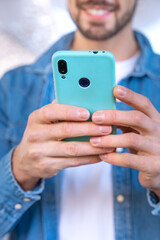 young man laughing using social networks with an app on his cell phone.