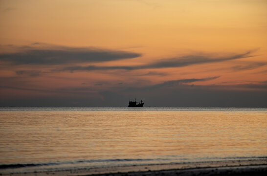 view of a floating boat in the sea in the evening