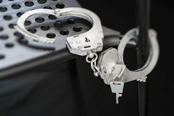 Handcuffs are lying on the bench for prisoners in the detention center. Chained to the metal part of the bench.