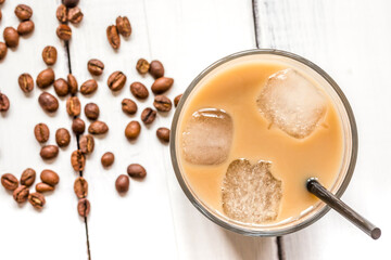 coffee ice cubes and beans with latte on white desk background top view