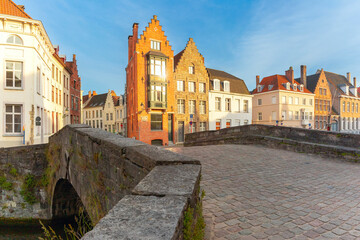 Fototapeta na wymiar Scenic city view of Bruges canal, medieval houses and sunny bridge at sunset, golden hour, Belgium