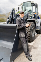 Serviceman with digital tablet on a background of the tractor.