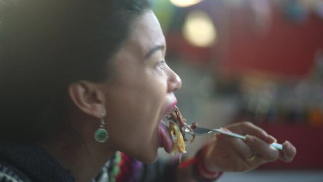 A close-up video captures an Asian traveler savoring a traditional pork dish in Cusco, Peru, known as "chicharr&oacute;n de chancho," served with rice and accompanied by vegetables on the side.