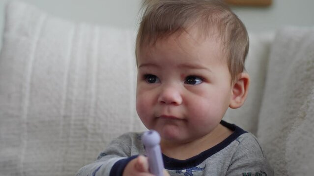  closeup shot of a baby boy chewing on a teething straw