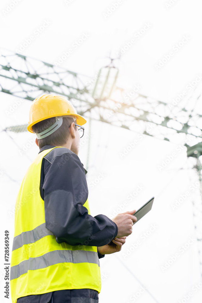 Aufkleber Engineer with digital tablet on a background of power line tower.