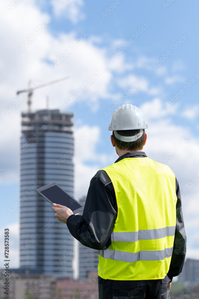 Aufkleber engineer with a digital tablet on the background of a building under construction