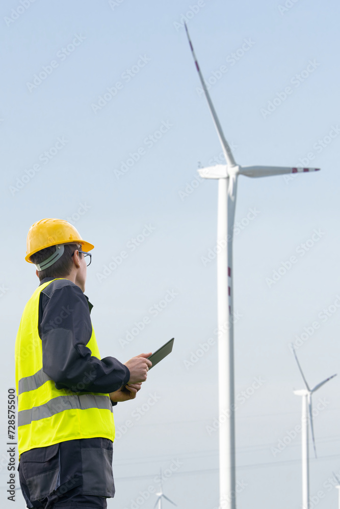 Poster Engineer with tablet computer on a background of wind turbines