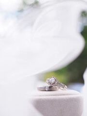 Diamond engagement wedding rings on bridal veil. Wedding accessories. Valentine's day and Wedding day concept.