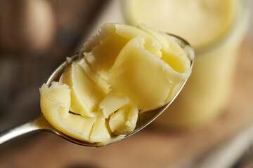 Ghee or clarified butter on a metal spoon, close up