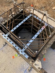 High angle shot of a formwork ready to pour concrete. Reinforced concrete column during the process of frameworking. Close up shot of the rebars of a pillar.