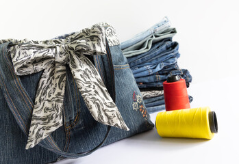 Old jeans and denim bag with sewing accessories, recycling concept, crafting with denim