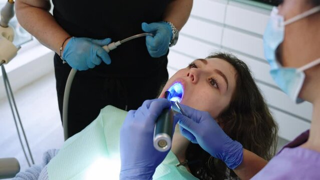 Dentist makes dental filling with dental polymerization lamp in an innovative clinic
