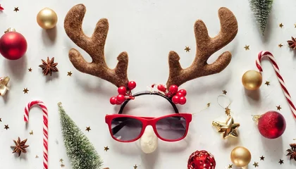 Fotobehang christmas deer concept creative layout made of reindeer antlers hipster glasses and christmas decoration on white background minimal flat lay new year holiday idea greeting card © Kendrick