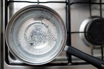 Saucepan stainless steel with boiling water on a gas stove