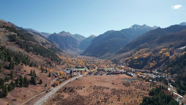 Distant pullback drone aerial view of Telluride, CO in the fall on a sunny day