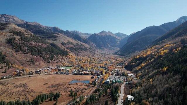 Distant drone shot showing all of the city of Telluride, CO in the fall
