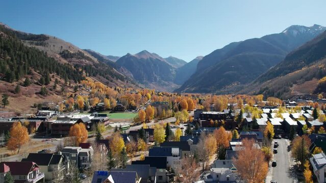 Low drone shot aerial over the center of Telluride, CO with bright fall trees