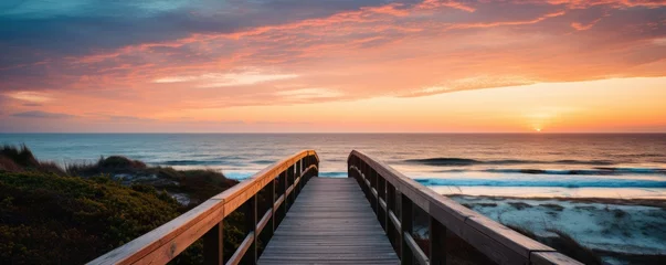 Papier Peint photo autocollant Descente vers la plage Long boardwalk leading to sand beach and ocean at sunset