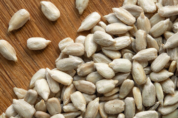Close up macro shot of shelled sunflower seeds on a wooden background. Top view.