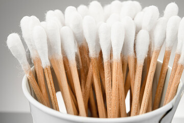 Lots of wooden cotton swabs in a decorative bucket. Close-up.