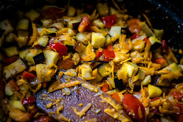 essence of French cooking captured as a chef stirs ratatouille on a gas stove.