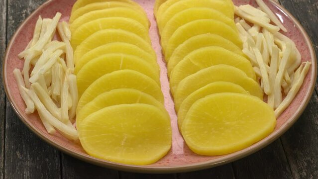 Asian style pickle: turmeric pickled daikon (takuan) and bamboo shoots. Table spin.
