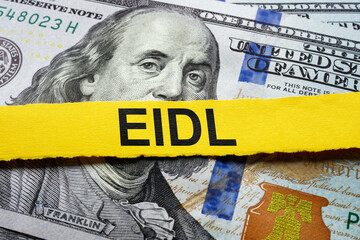 A pack of dollars and a strip with an inscription EIDL Economic Injury Disaster Loan.
