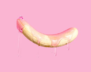 Peeled banana dripping pink gel on pink background.