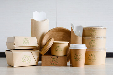 A set of disposable tableware made of cardboard and paper with recycling signs. Packaging for food delivery or for a picnic made from environmentally friendly materials.