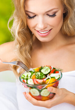 Portrait image - happy smiling young blond blonde woman looking down at vegetable salad home house interior, indoors. Healthy eating, vegetarian, keto ketogenic diet concept.