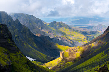 Volcanic mountains with snow and green moss on hills on Icelandic highlands in Iceland. Famous...