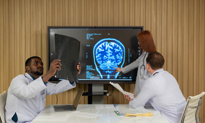 Multicultural Medical Team Discussing Patients MRI Film in Hospital Setting