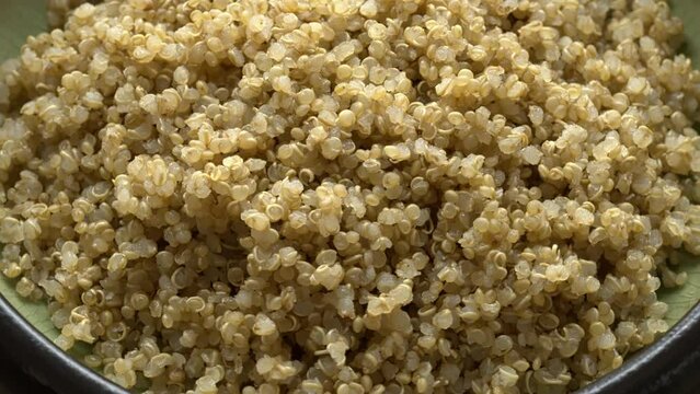 Cooked quinoa in a ceramic bowl. One of the World's healthiest foods. Table spin.