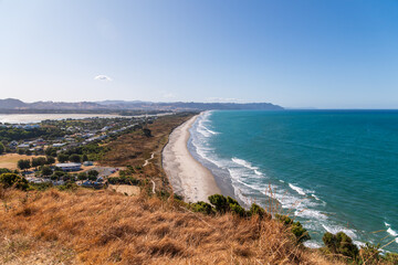 Sunny summer day at Waihi Beach, New Zealand. Ideal for travel brochures, vacation advertisements, or any project seeking to capture the beauty of coastal landscapes and serene beach destinations.