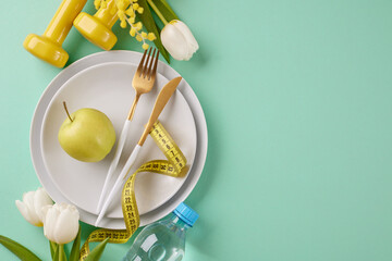 Energize and trim: spring into healthy weight loss habits. Top view shot of plates, cutlery, apple,...