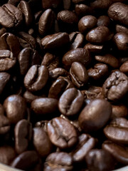 Closeup of glossy coffee beans with selective focus on foreground