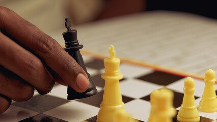 Close up of black man playing chess on a chessboard Selective focus