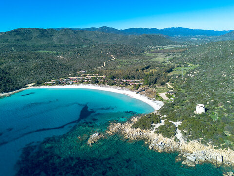 Cala Pira beach and tower, with white sand and crystal clear water seen from above with drone. Castiadas, Sardinia, Italy