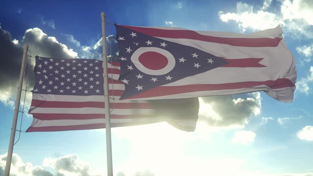 The Ohio state flags waving along with the national flag of the United States of America. In the background there is a clear sky