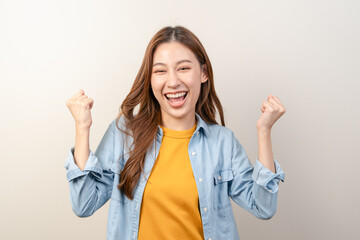 Joyful young asian woman celebrating achievement isolated on background