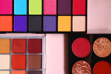 Various colorful eyeshadow palettes on bright pink background. Flat lay.