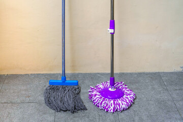 two simple, modern floor mops leaned against the wall