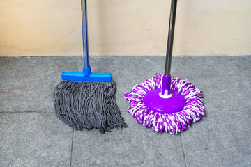 two simple, modern floor mops leaned against the wall