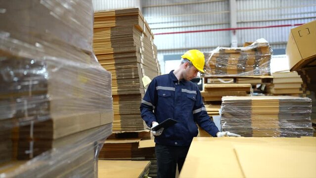 Caucasian businessman checking Kraft paper stock in warehouse	